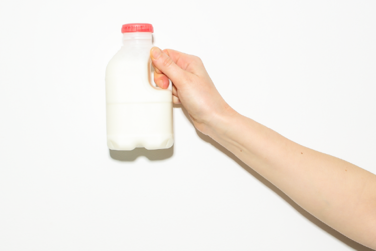 Person holding up a milk bottle